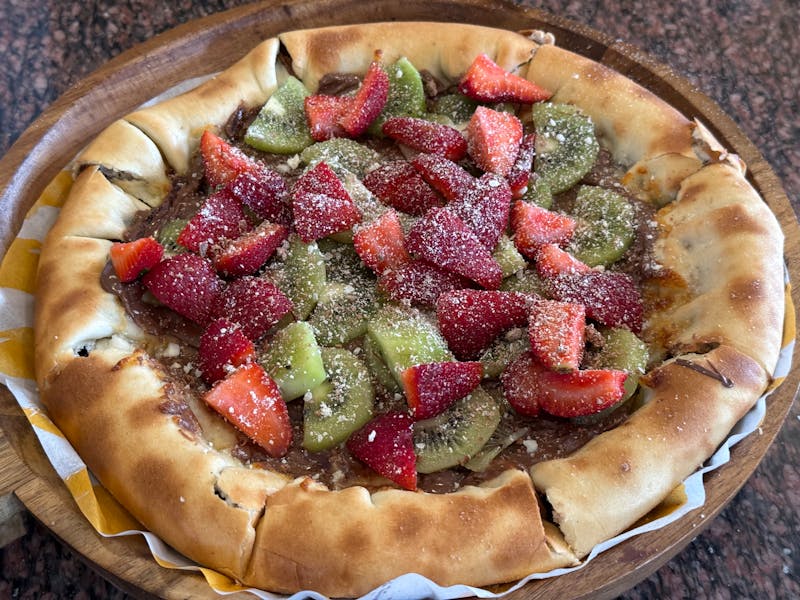 Dessert Nutella pizza with strawberries and powdered sugar